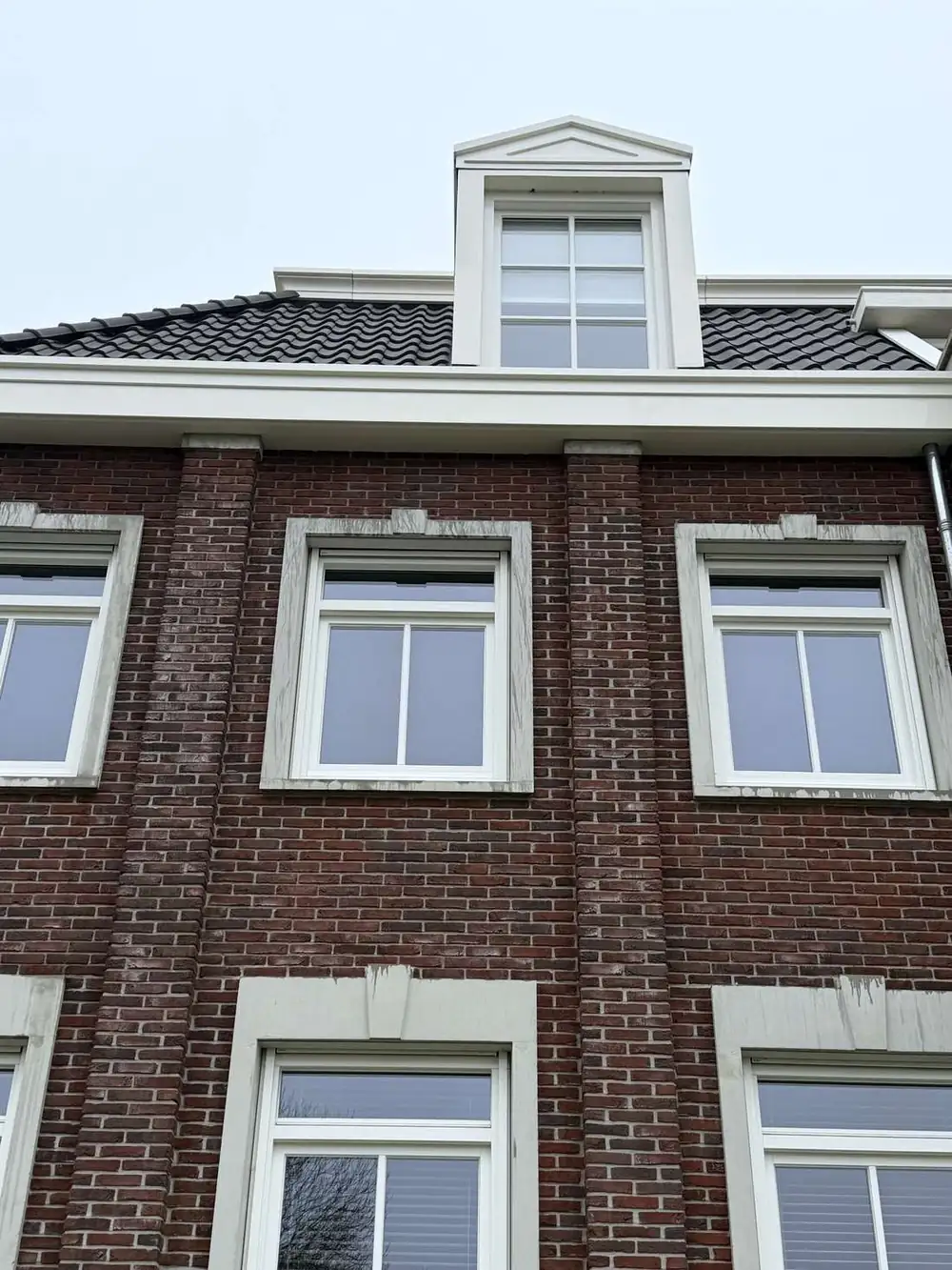 Glasbewassing aan een kantoorpand met hoogwerker en telescoopsteel