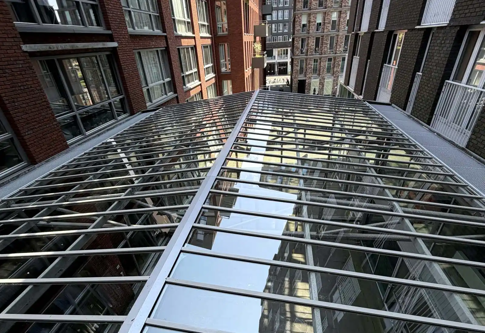 Glazen daklichtstraat tussen gebouwen, schoongemaakt door SR Allround Service