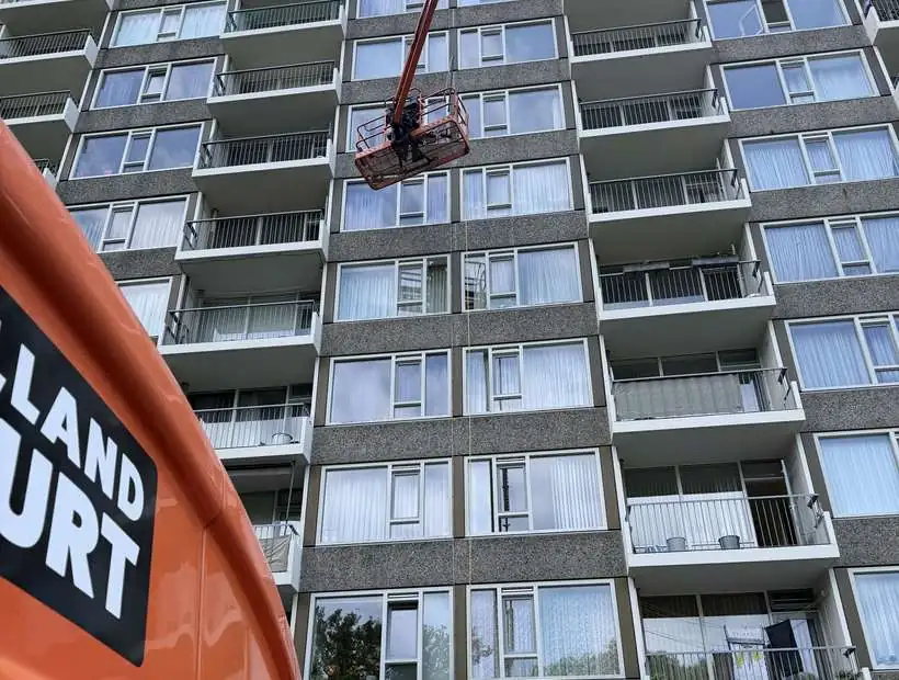 Hoogwerker bij een appartementencomplex voor glasbewassing op hoogte