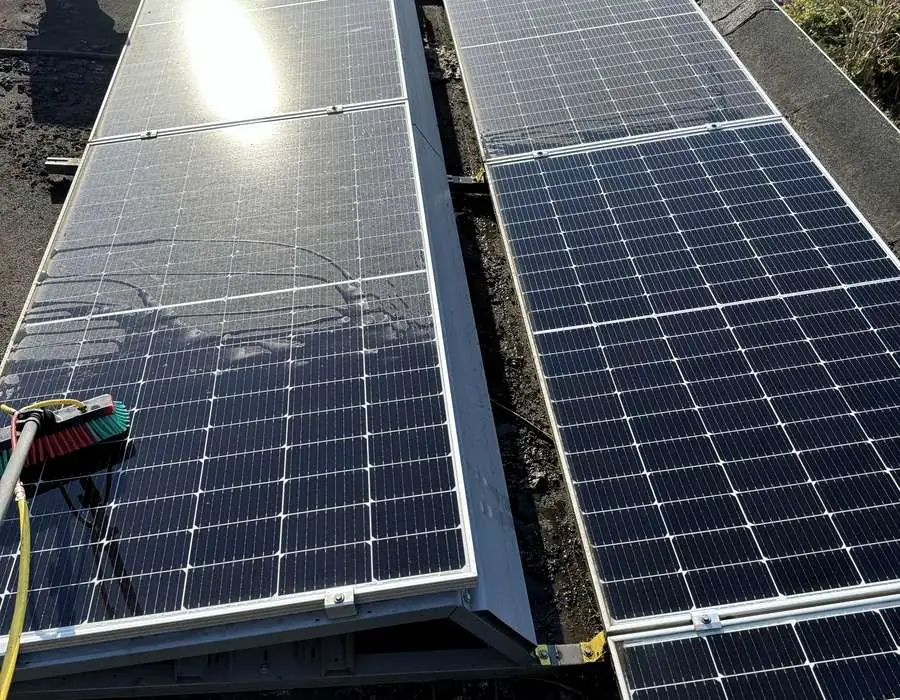 Zonnepanelen op een dak worden gereinigd met een borstel