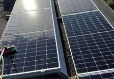 Zonnepanelen op een dak worden gereinigd met een borstel